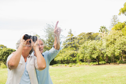 Man showing something to his wife with binoculars