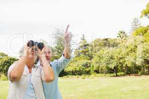 Man showing something to his wife with binoculars