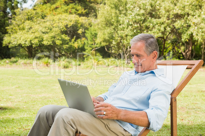 Smiling mature man using his laptop