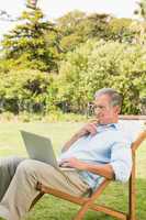Man using laptop on sun lounger
