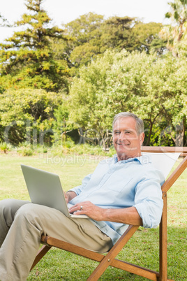 Smiling mature man using laptop