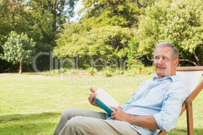 Happy mature man holding book