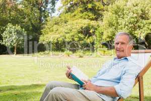 Happy mature man holding book