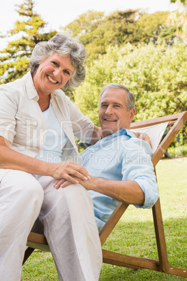 Smiling mature couple resting on sun lounger