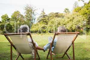 Happy mature couple sitting in park