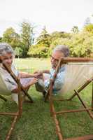 Smiling mature couple lying on sun loungers