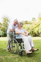 Happy mature woman in wheelchair with partner