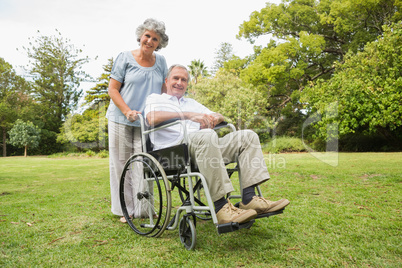 Happy mature man in wheelchair with partner