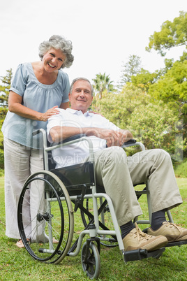 Smiling mature man in wheelchair with partner