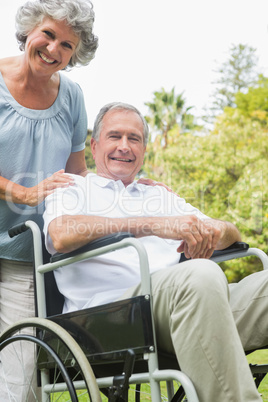 Cheerful mature man in wheelchair with partner