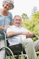 Cheerful mature man in wheelchair with partner