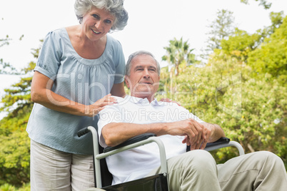 Cheerful mature man in wheelchair with his partner
