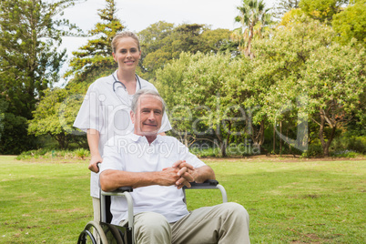 Man sitting in a wheelchair with his nurse pushing him