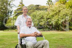 Man sitting in a wheelchair with his nurse pushing him