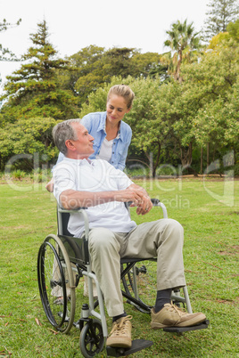 Happy man in wheelchair and daughter talking