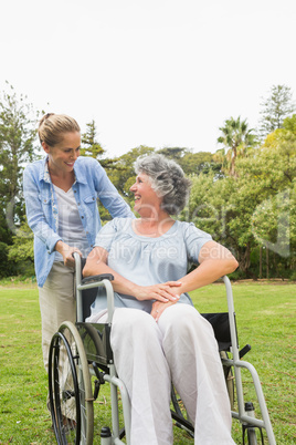 Happy mature woman in wheelchair talking with daughter