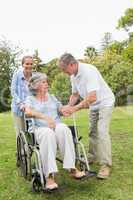 Mature woman in wheelchair with husband and daughter