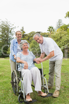 Woman sitting in wheelchair with husband and daughter