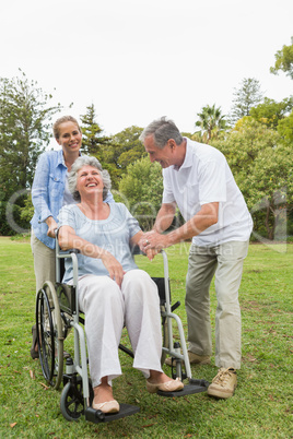 Retired woman in wheelchair with husband and daughter