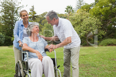 Happy woman in wheelchair with husband and daughter
