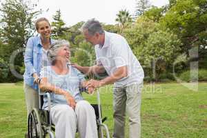 Happy woman in wheelchair with husband and daughter