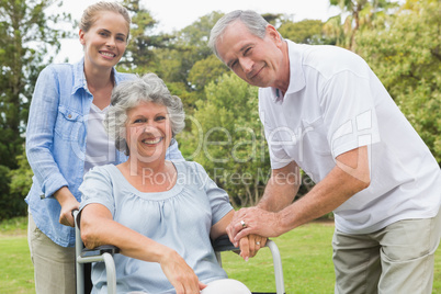 Smiling woman in wheelchair with daughter and husband