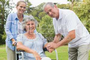 Smiling woman in wheelchair with daughter and husband