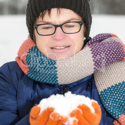 Woman holding snow in their hands