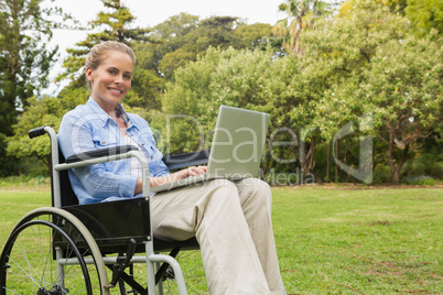 Smiling woman in a wheelchair with a laptop