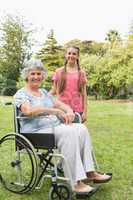 Smiling granddaughter with grandmother in her wheelchair