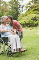 Granddaughter kissing cheek of grandmother in wheelchair