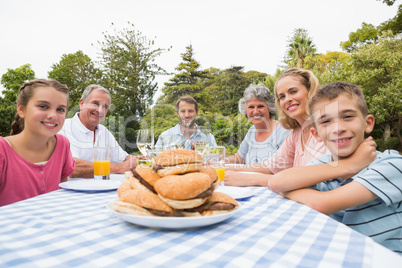 Extended family eating outdoors at picnic table