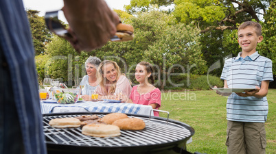 Little boy waiting for barbecue cooked by father
