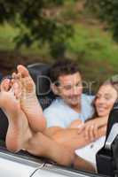 Happy couple cuddling in the backseat with focus on foot