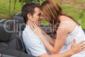Young couple feeling romantic in back seat