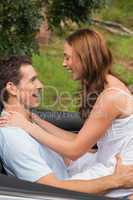 Young couple feeling romantic in back seat and laughing