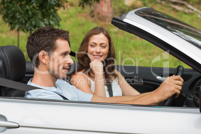 Young couple driving in a silver convertible