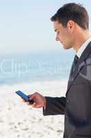 Concentrated businessman sending a text message