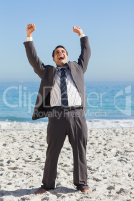 Victorious businessman in suit holding arms up