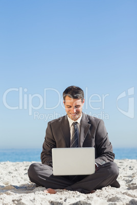 Young businessman with legs crossed with his laptop