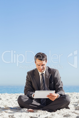 Young businessman siiting using his tablet computer