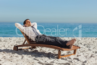 Young businessman relaxing on a deck chair