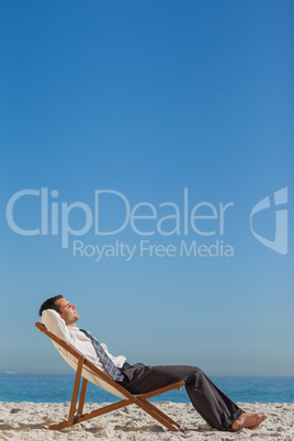 Young businessman resting on his deck chair