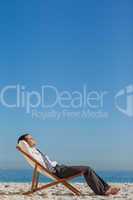 Young businessman resting on his deck chair