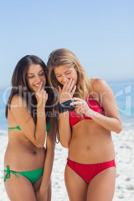 Two sexy friends looking at the pictures they just took