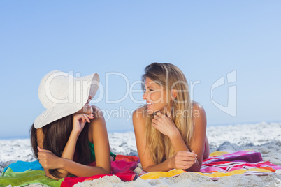 Two pretty women lying on the sand