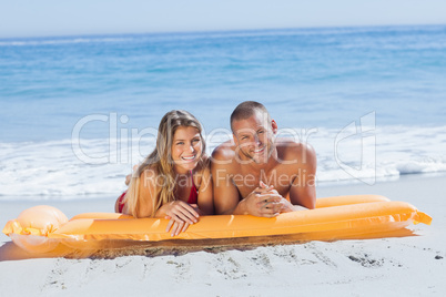 Smiling cute couple in swimsuit taking sun