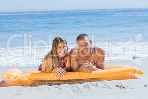 Smiling cute couple in swimsuit taking sun