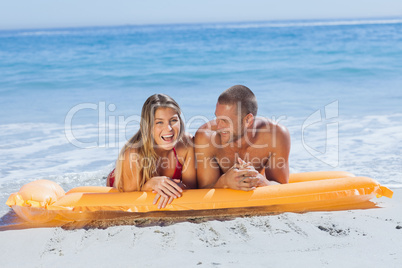 Cheerful cute couple in swimsuit taking sun