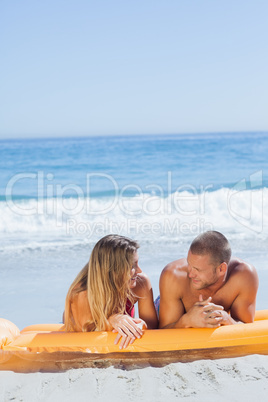 Cheerful cute couple in swimsuit relaxing together